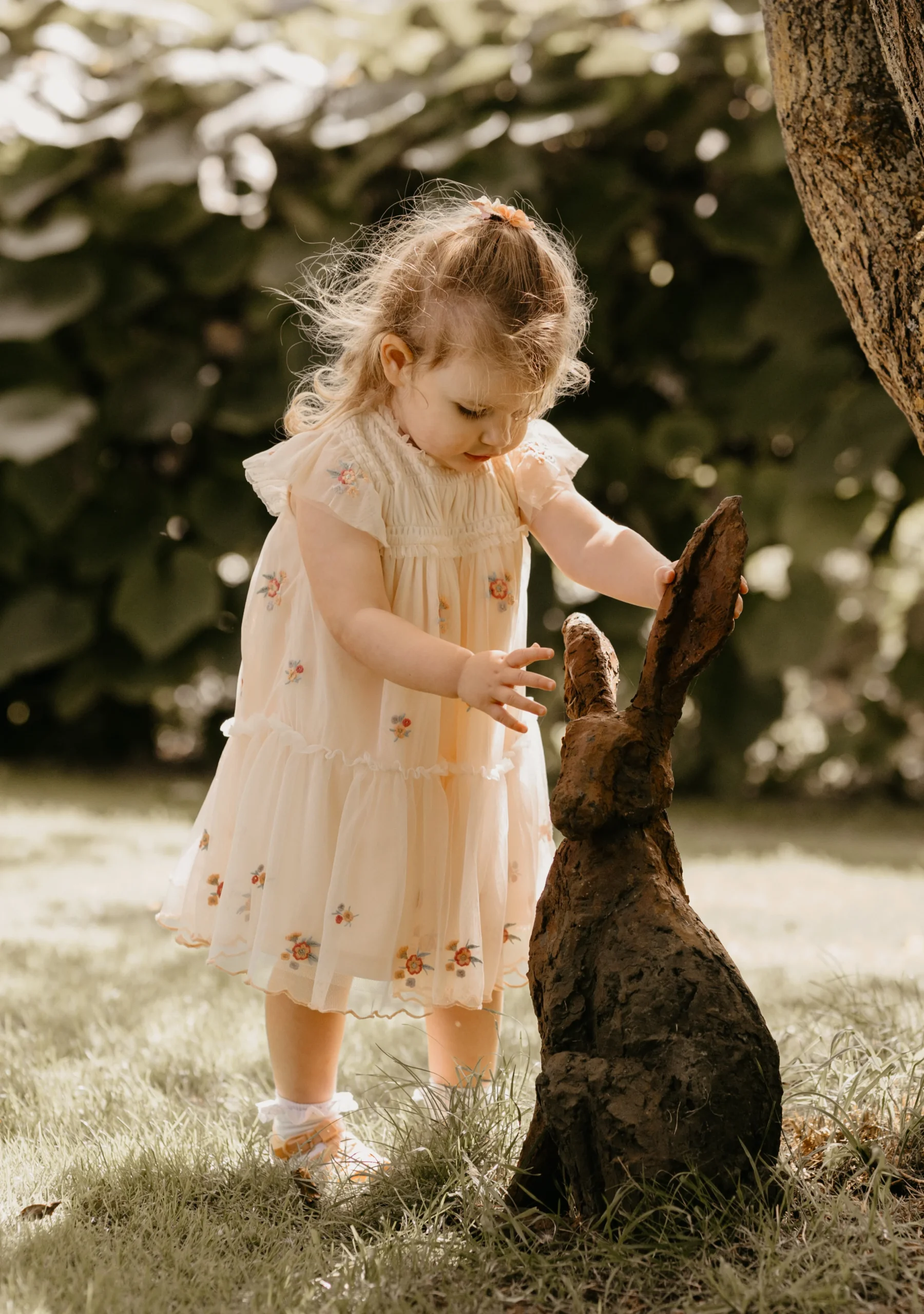 Toddler playing with a Rabbit Sculpture